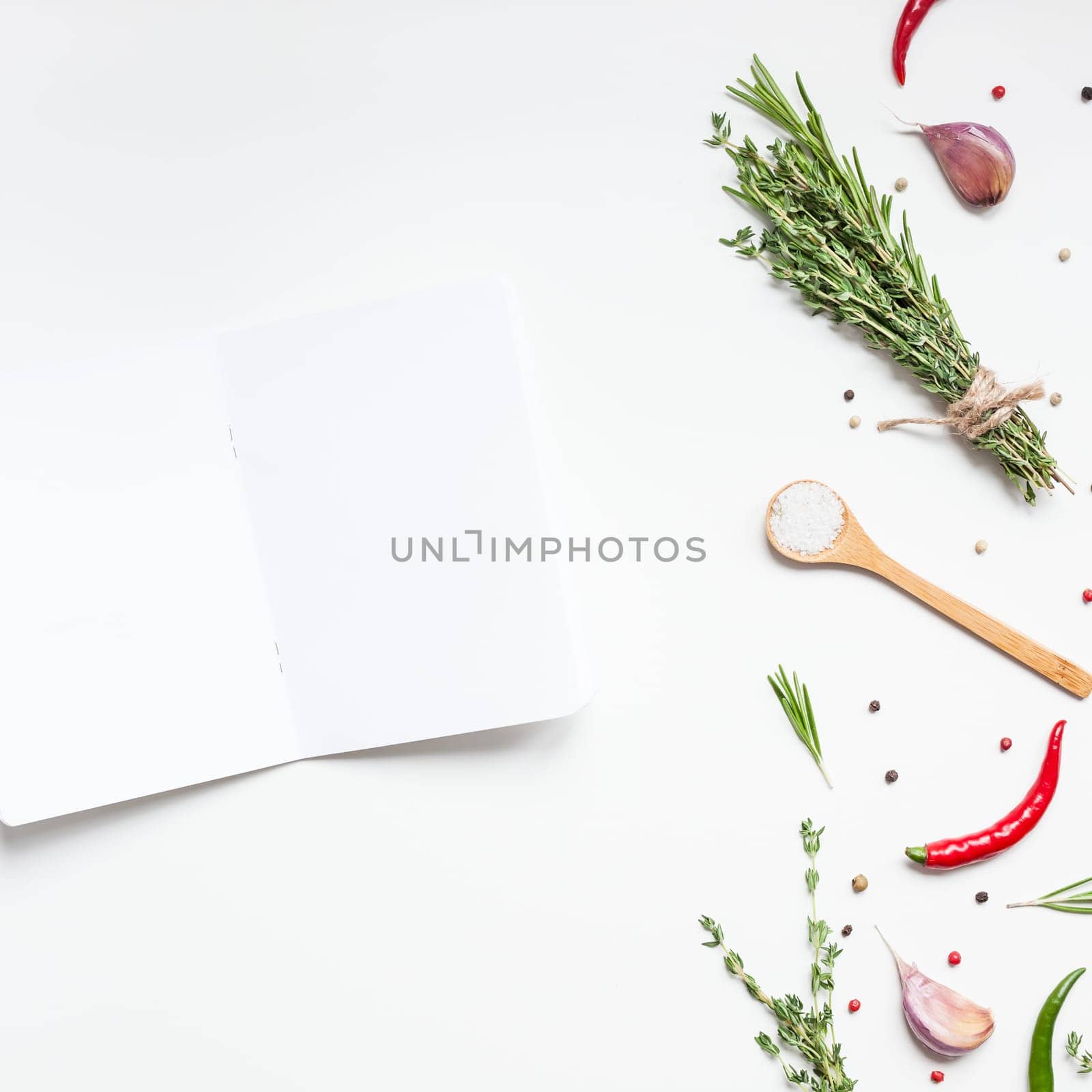 Flat lay overhead view blank notebook pages mockup text space invitation card on white background with greens herbs and spices. Menu or recipe book or food blog design with cooking ingredients