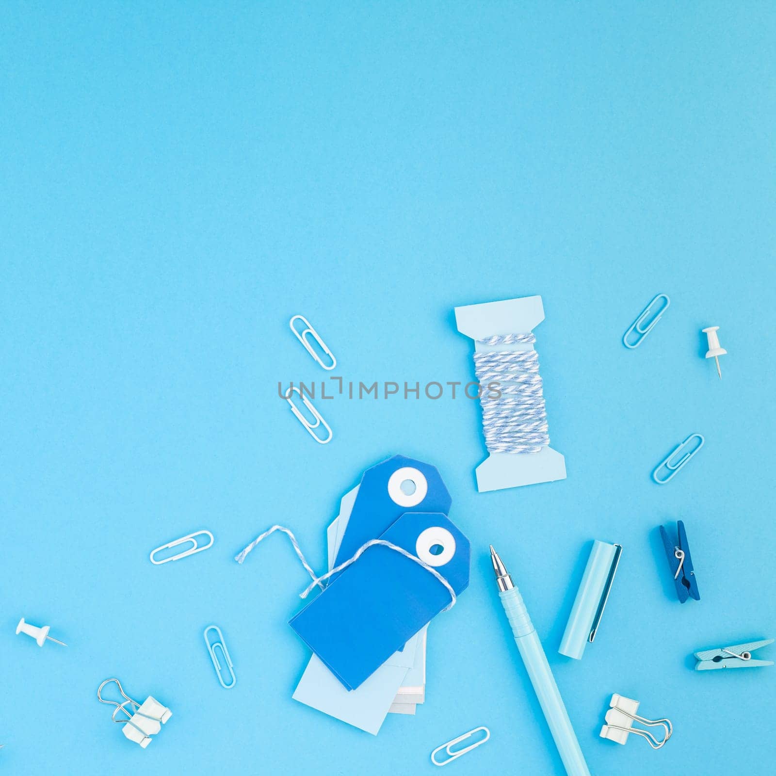 Top view flat lay of workspace desk styled design handcrafting holiday decor tags office supplies with copy space turquoise blue color paper background. Square Template for feminine blog social media