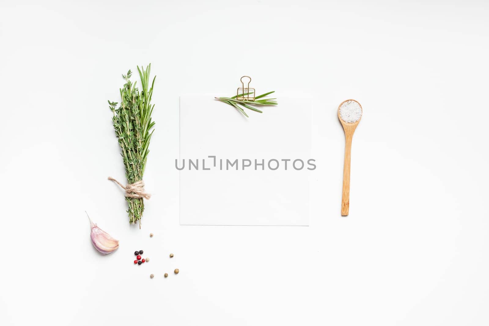 Flat lay overhead view blank recipe paper page with clip mockup text space invitation card on white background with greens herbs and spices. Menu recipe book food blog design with cooking ingredients