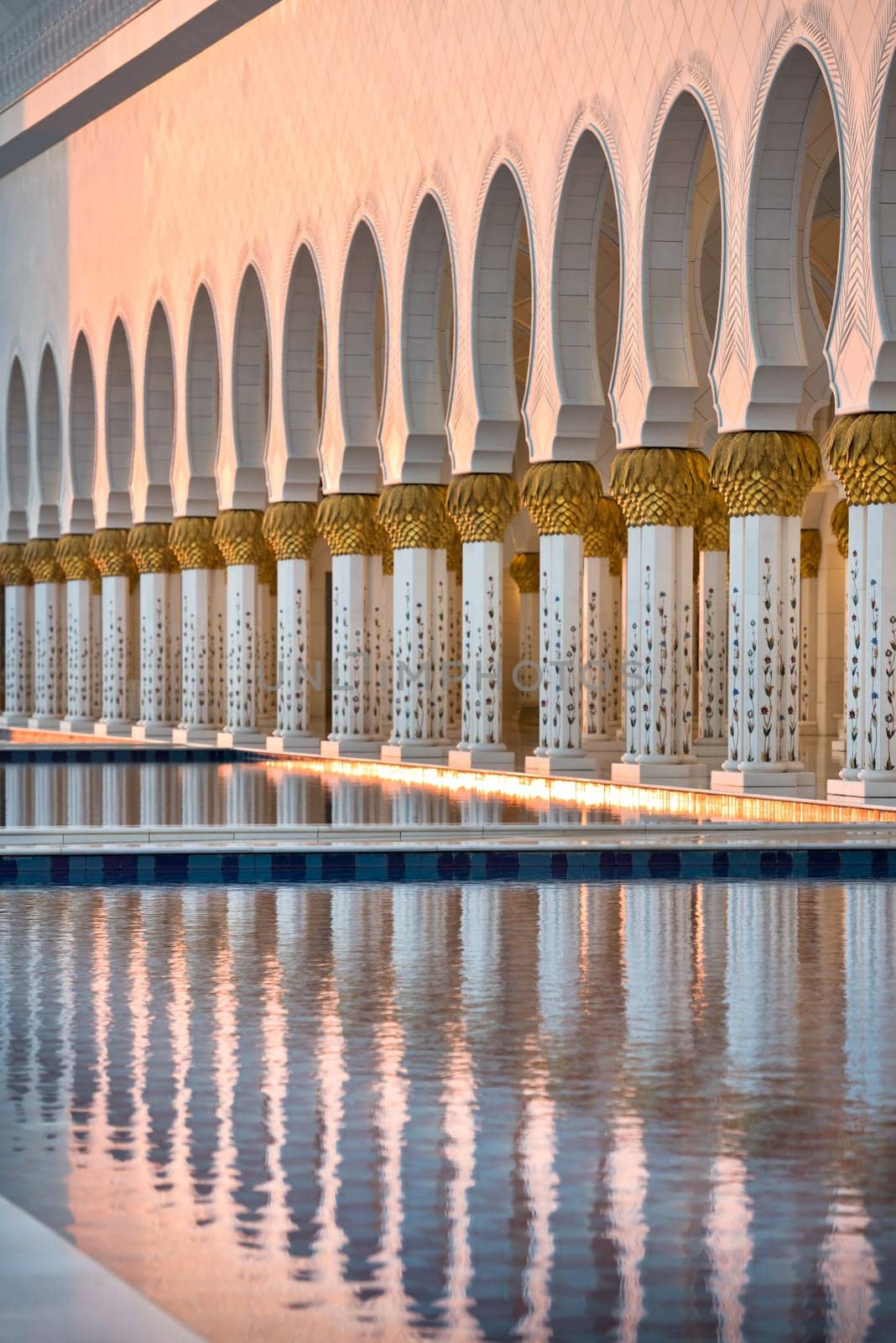 Beautiful gallery of famous Sheikh Zayed White Mosque in Abu Dhabi, UAE. Reflections at sunset