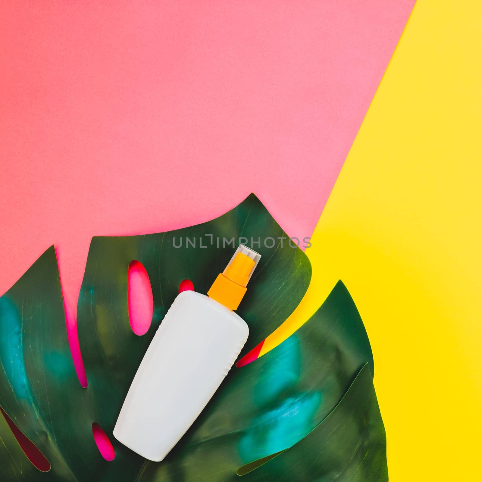 Tropical jungle palm monstera leaves and sunscreen blank bottle mockup on bright square yellow and pink duotone paper background. Summer vacations creative flat lay concept template for text