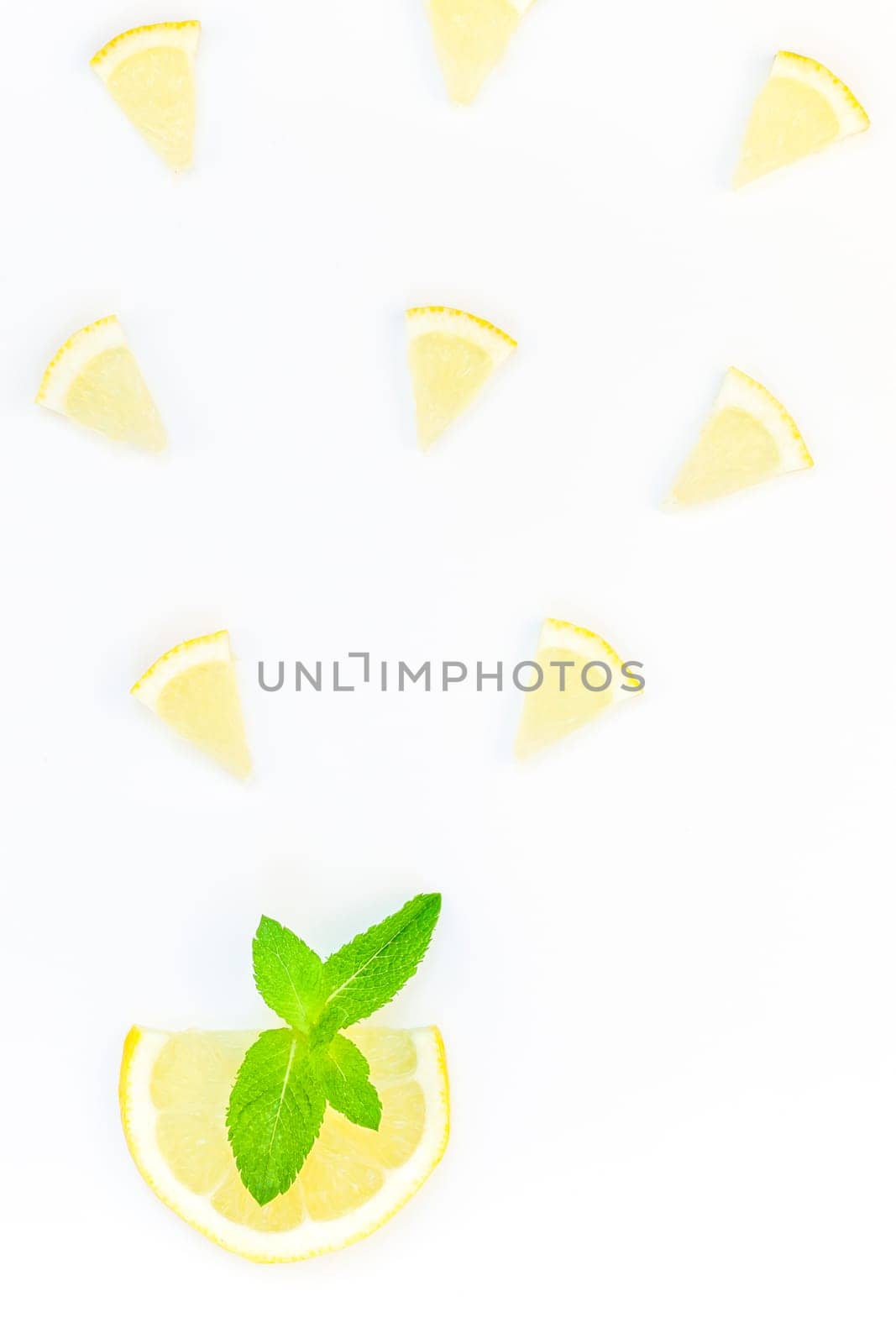 Creative flatlay overhead top view citrus lemon slices and mint herbs leaves white table background with copyspace. Hot summer refreshment lemonade concept. Beverage ingredients arranged