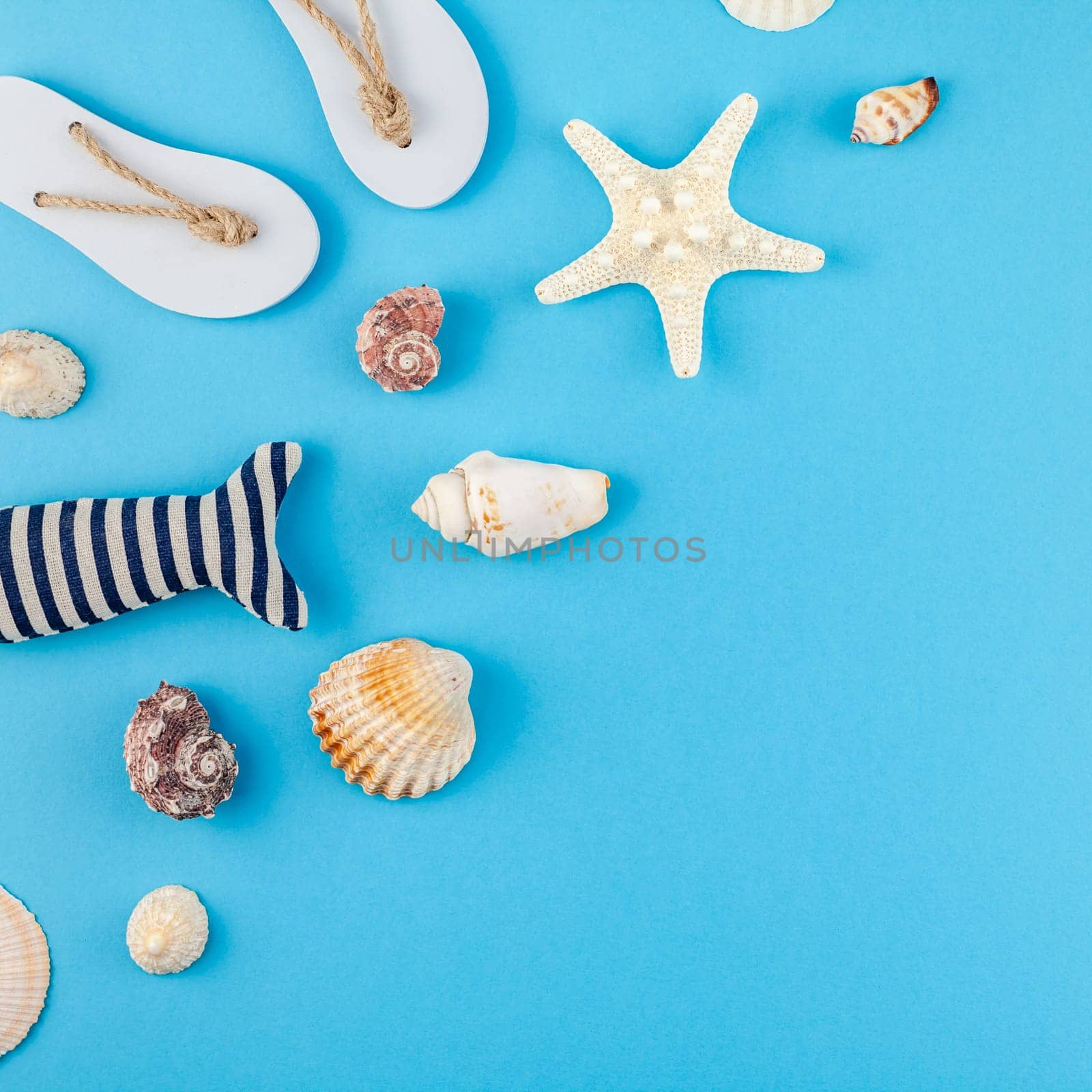 Creative flat lay concept of summer travel vacations. Top view of seashells and starfish on turquoise blue background with postcard mock up and copy space in minimal style, template for text
