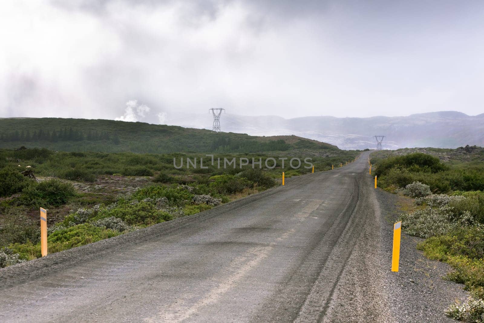 Gravel Road through Geothermal Area in Iceland. Clouds of steam