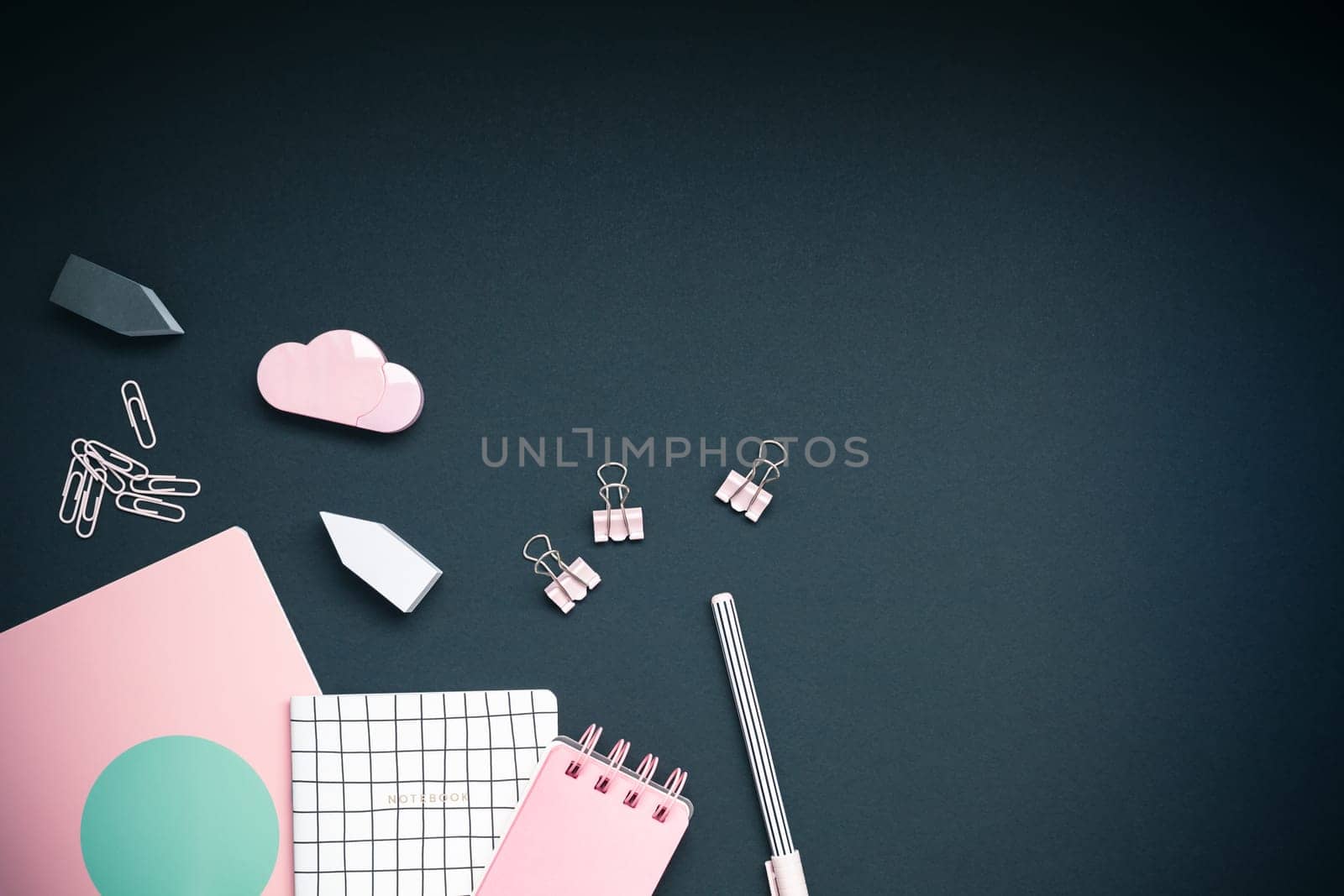Top view flat lay feminine desk workspace styled pink colored objects design office supplies with copy space on black background. Template for blog social media