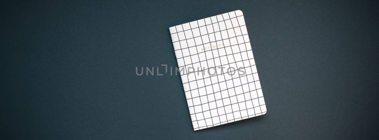 Top view flat lay of pattern notepad with copy space on black color paper background in minimal style. Template for feminine blog social media