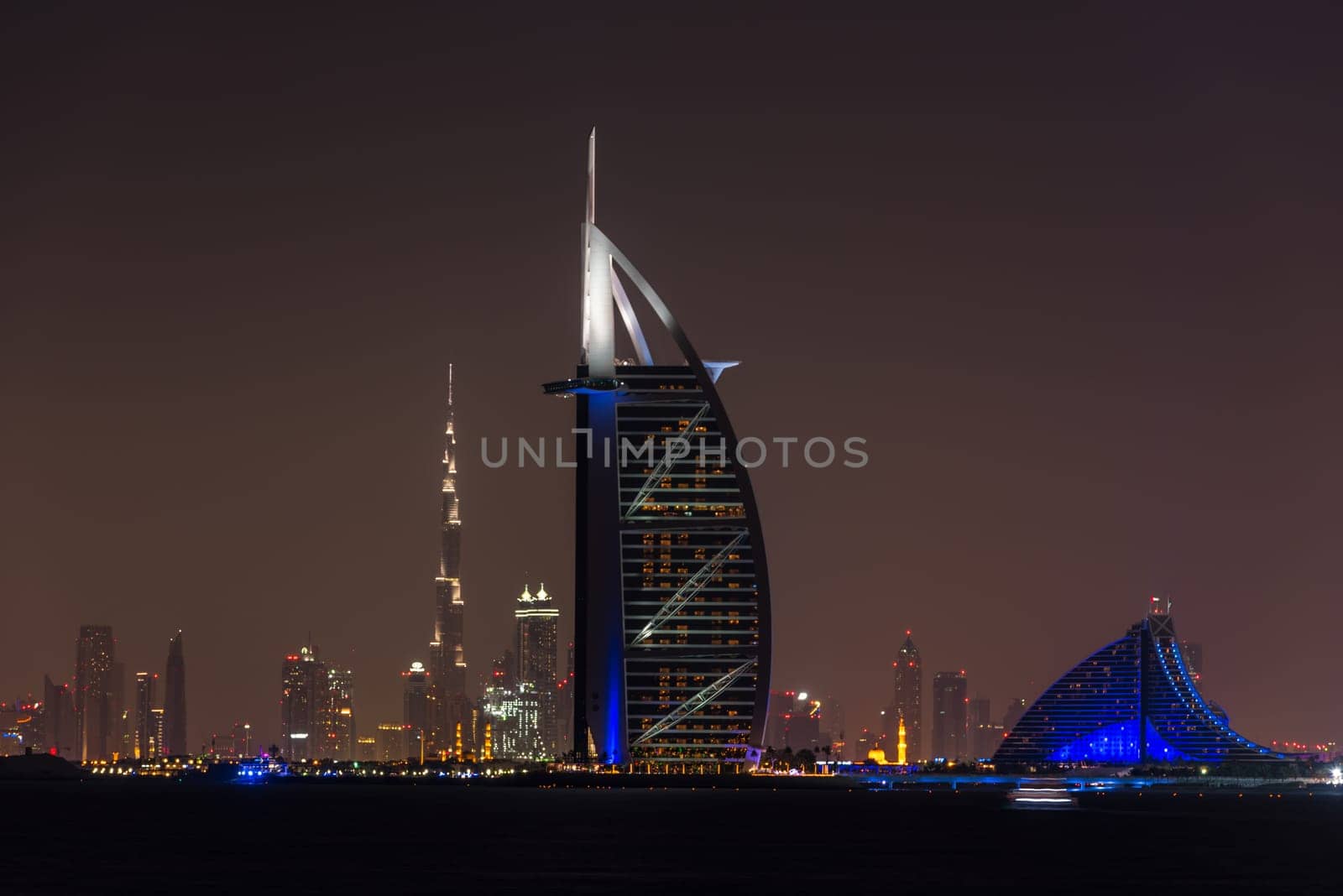 UAE, DUBAI - DECEMBER 26: Night cityscape of Dubai city with Burj Al Arab Jumeirah building on the front, United Arab Emirates on December 26, 2014