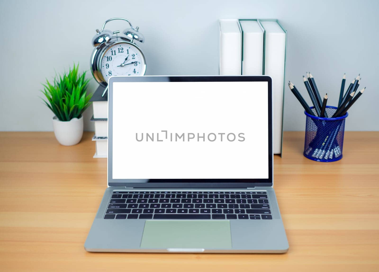 Space for copying your text. Laptop with blank screen on white table and office supplies on wooden background. Workspace and copy space. Desk with office supplies.