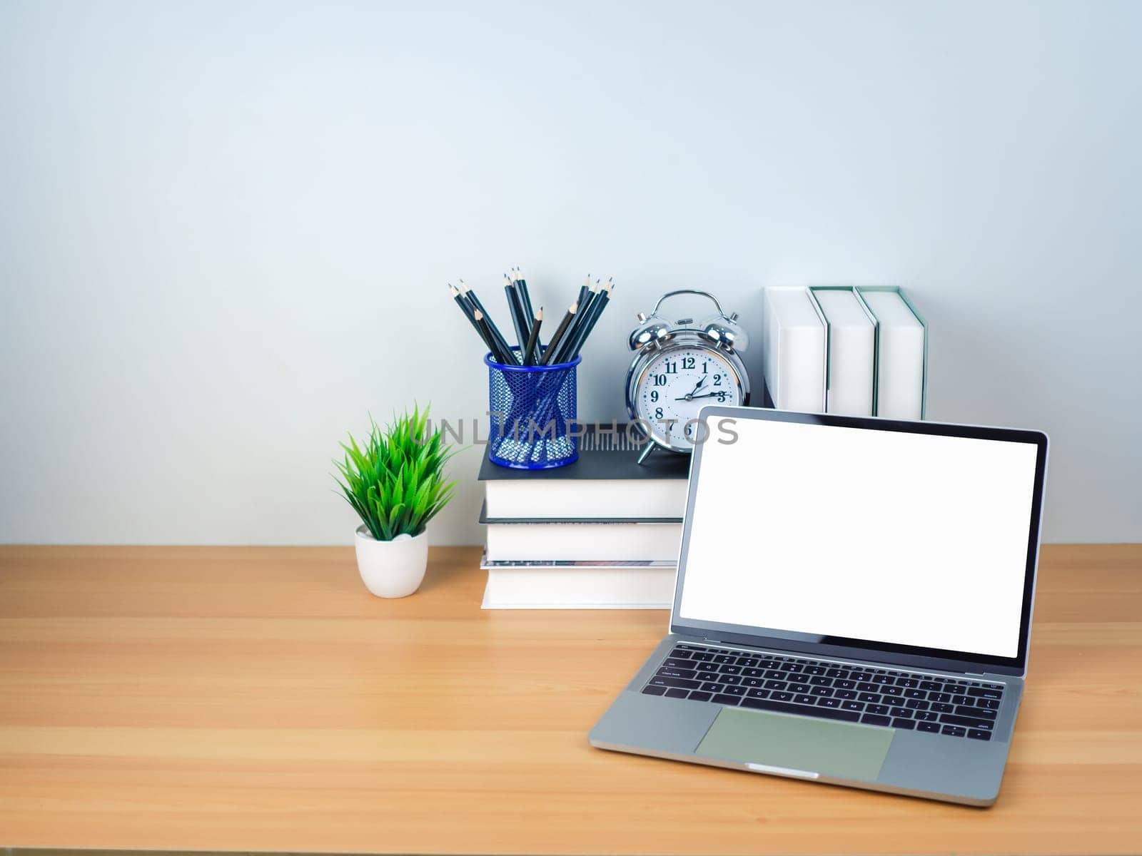 Space for copying your text. Laptop with blank screen on white table and office supplies on wooden background. Workspace and copy space. Desk with office supplies.