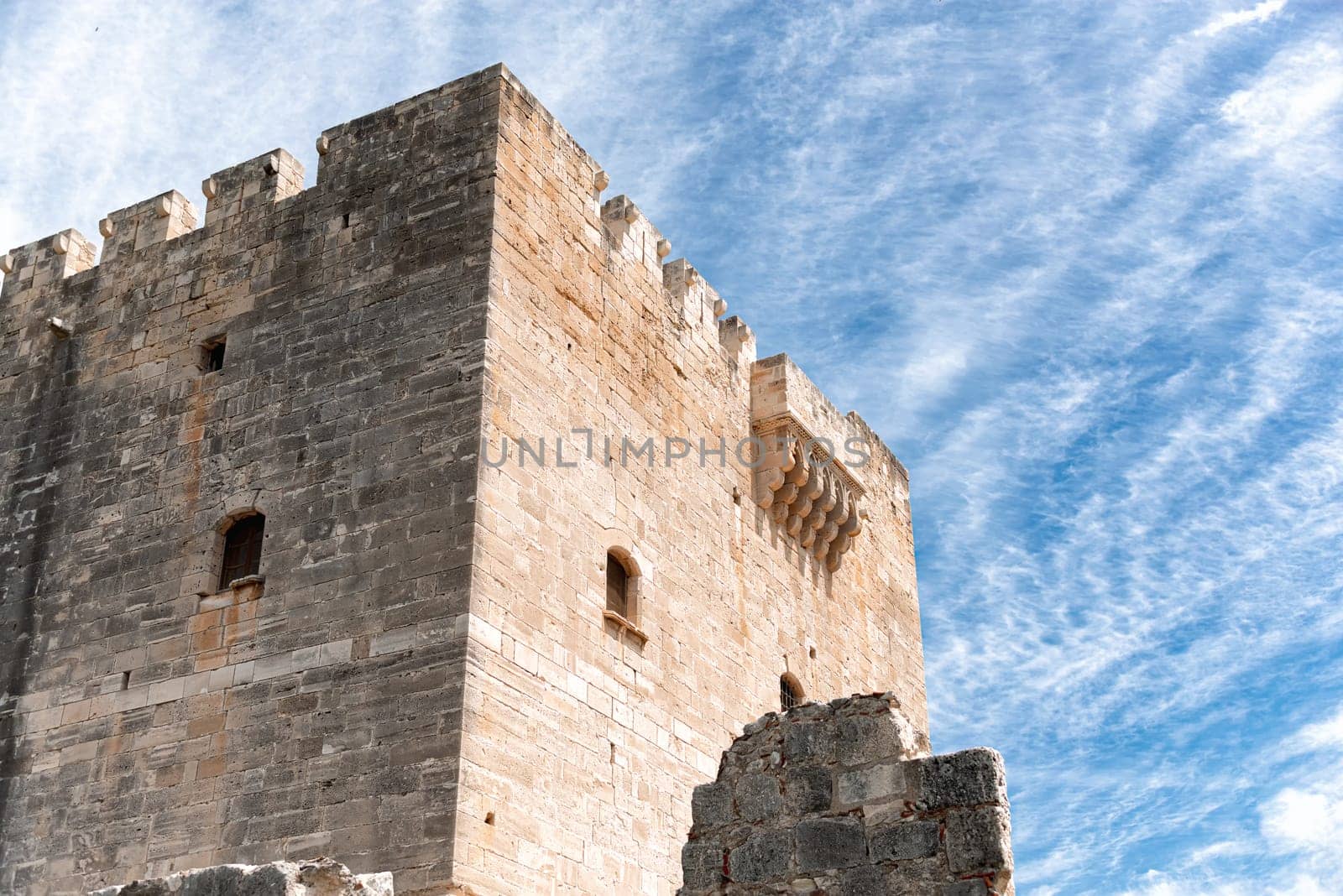 Kolossi castle with its dominating presence standing tall against a bright blue sky with clouds. Limassol District, Cyprus