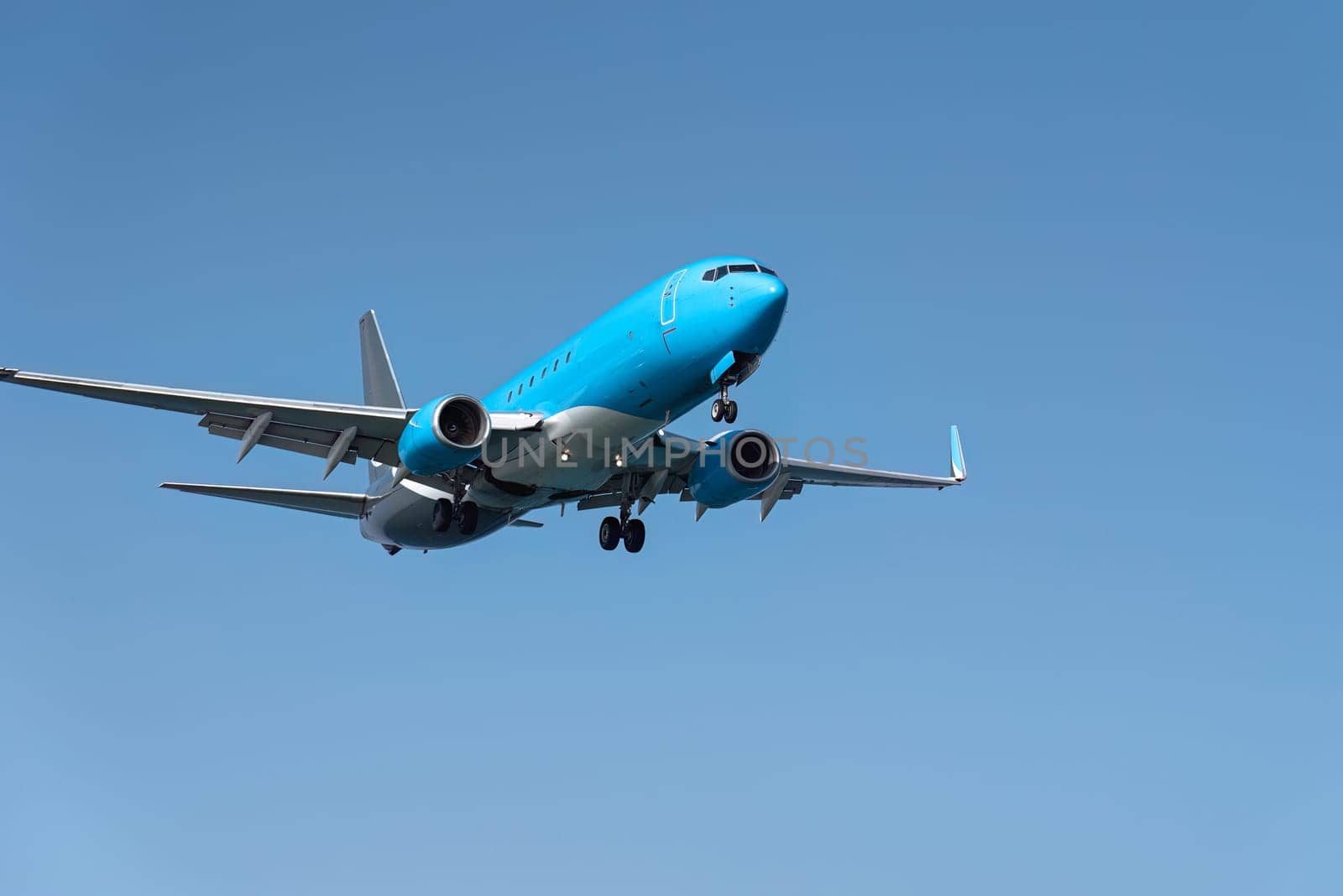 Large passenger plane is approaching an airport on a sunny day