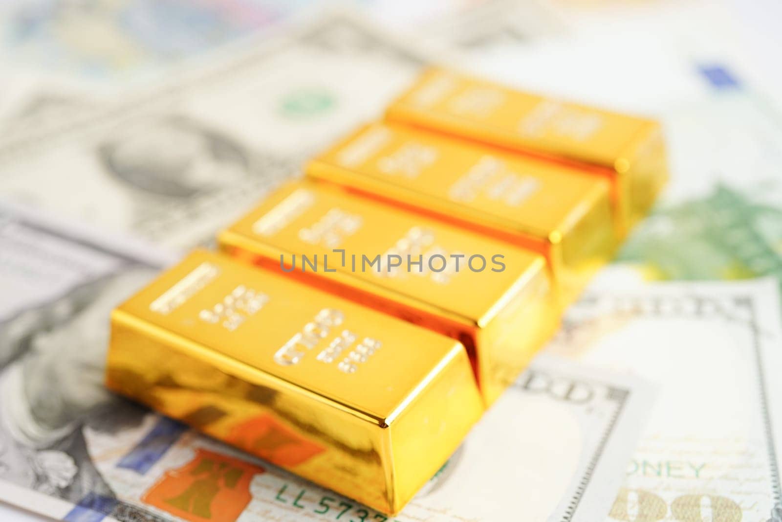 Gold bars on US dollar banknote money, finance trading investment business currency concept.