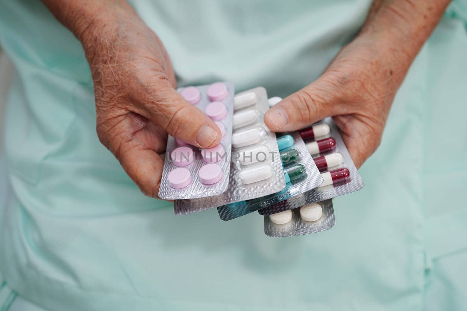 Asian elderly woman holding pill drug in hand, strong healthy medical concept.