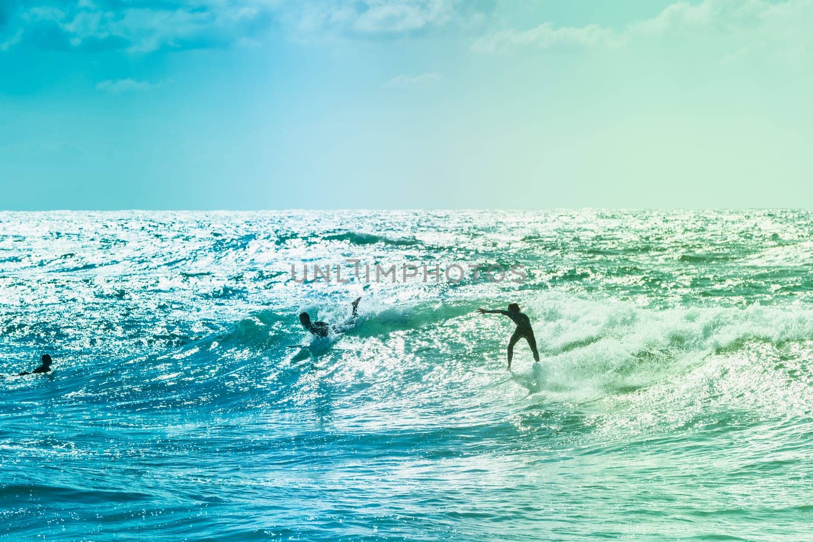 Extreme surfers riding some waves on the sea in France
