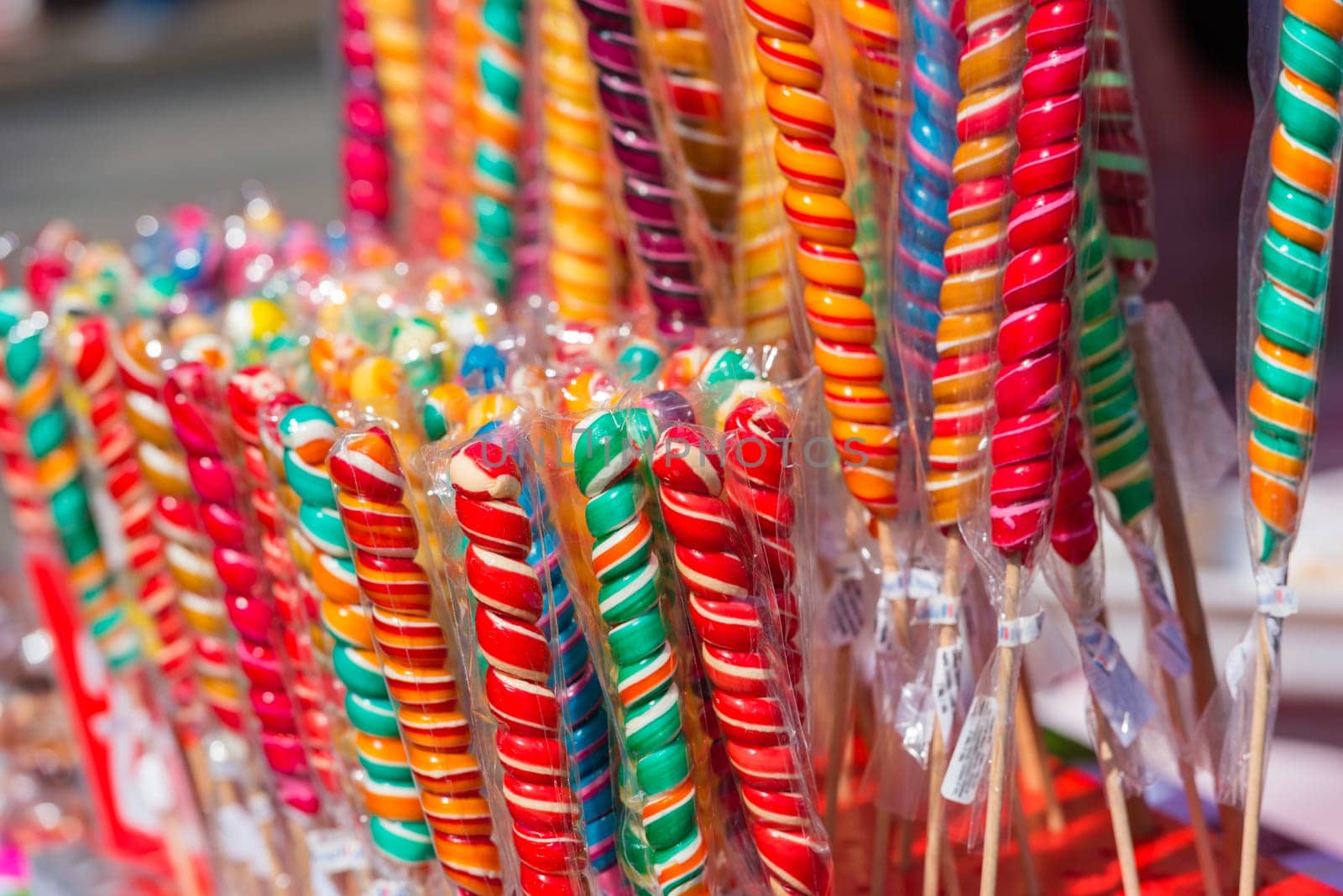 Close up of colorful handmade swirl lollipops on street market
