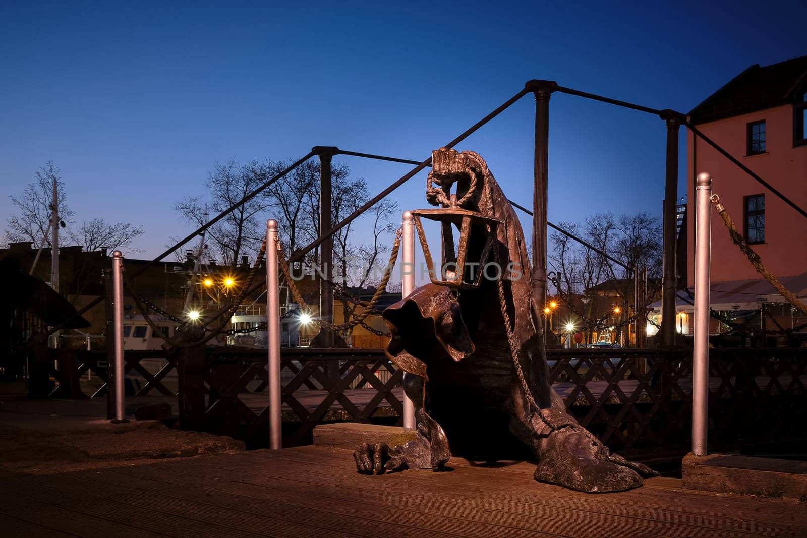 City attraction - statue in old port of Klaipeda, Lithuania. Legend of black no-face ghost with a lantern in gnarled hand come out of harbor waters.