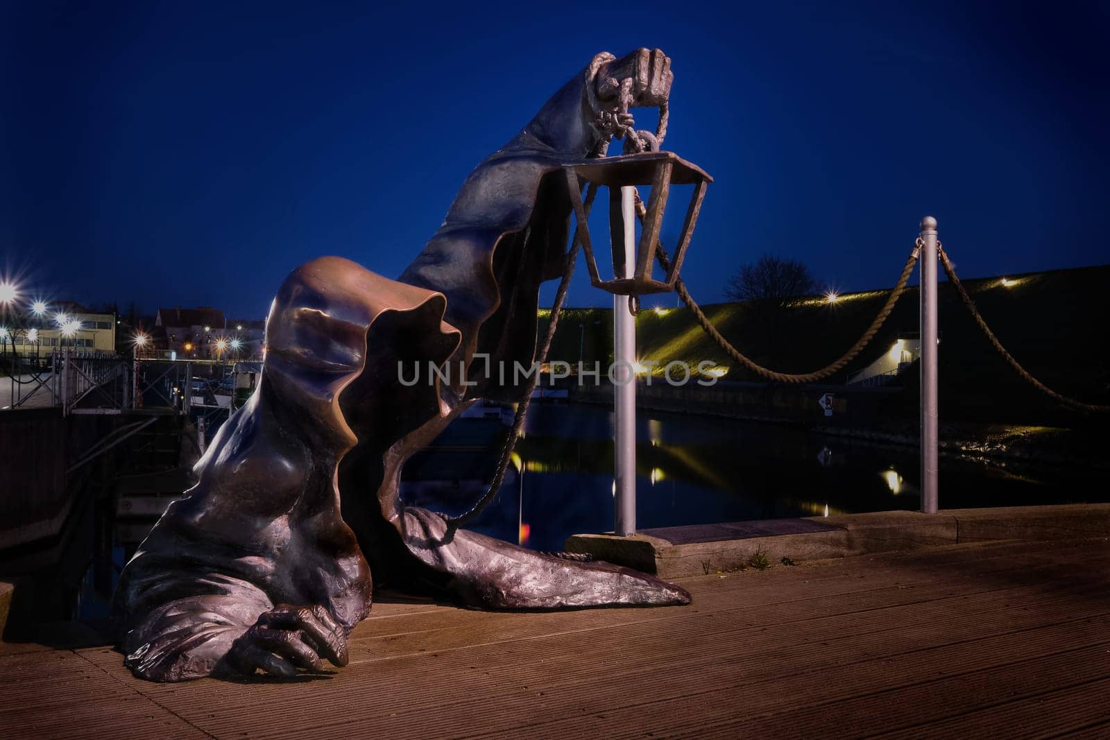 City attraction - statue in old port of Klaipeda, Lithuania. Legend of black no-face ghost with a lantern in gnarled hand come out of harbor waters.