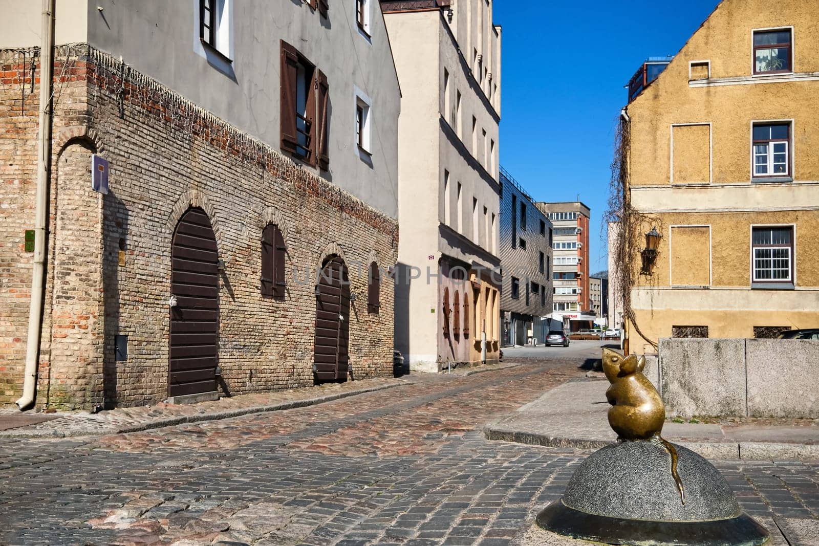 City attraction of tiny mouse street statue in old part of Klaipeda, Lithuania. City symbols, medieval towns, sunny day.