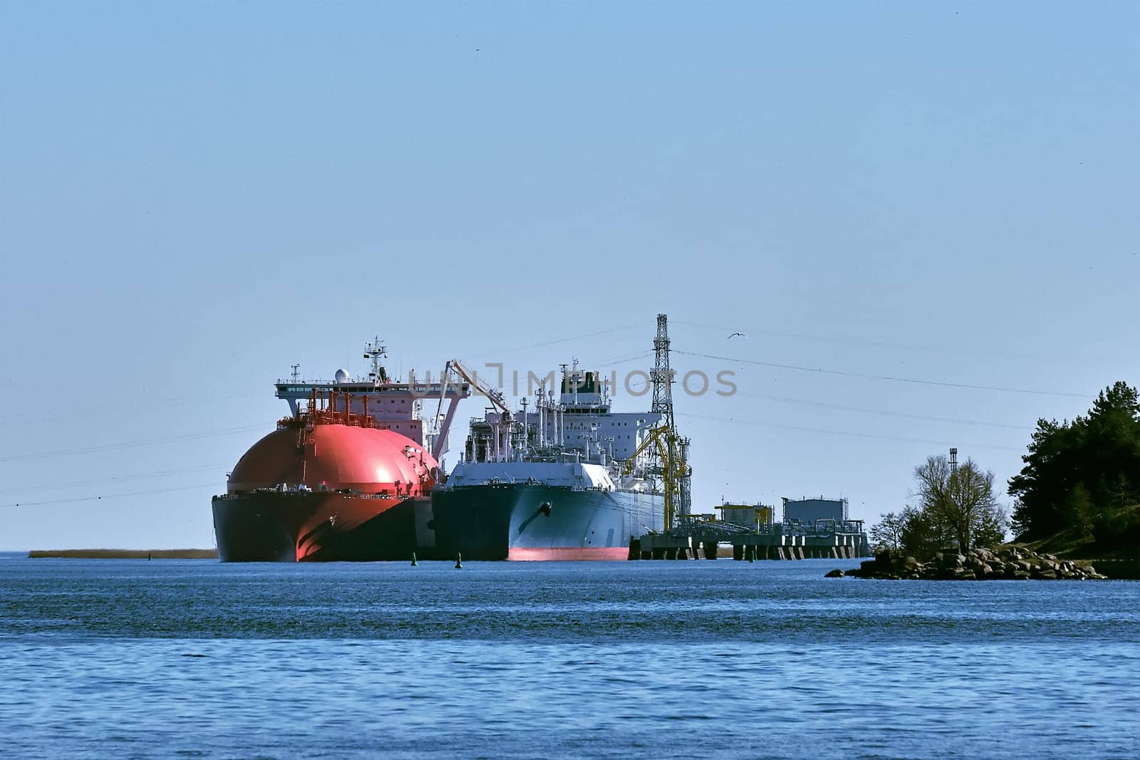 LNG or liquified natural gas tanker and LNG carrier used as floating LNG storage and regasification unit and import terminal in port on sunny day in Klaipeda, Lithuania. Alternative gas supply, commecial freight, energy crisis, diversification