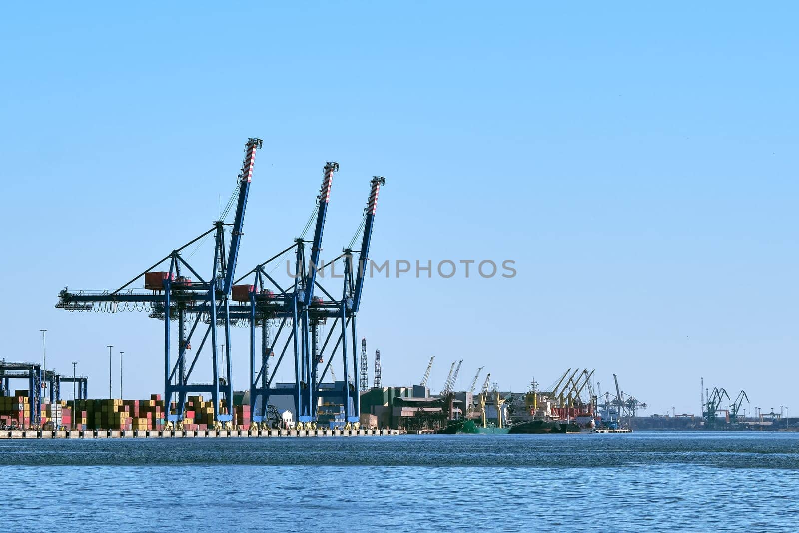 View of port cranes, loading bridges and container terminal. Sea trade, transportation, commerce and cargo