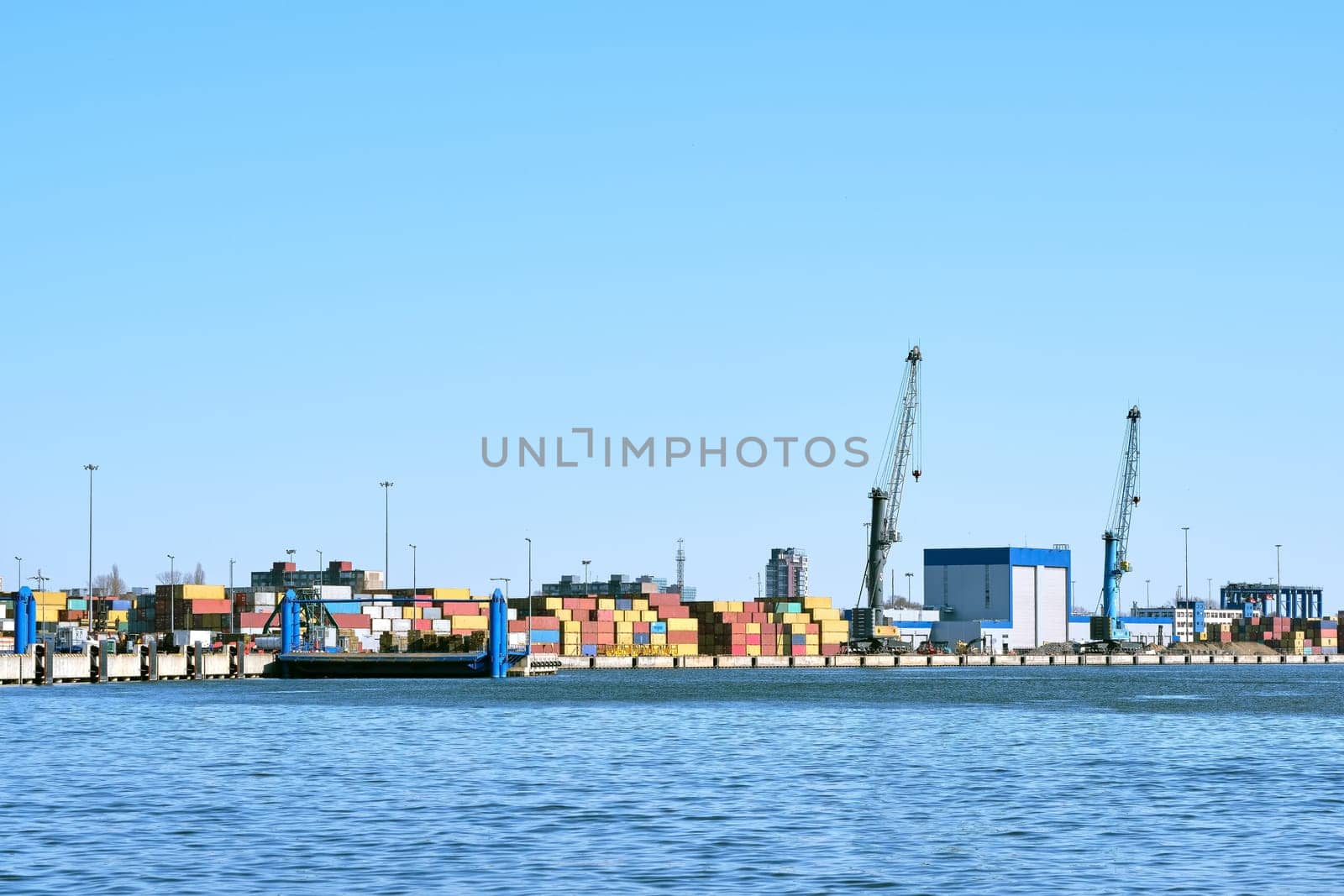 View of port cranes, loading bridges and container terminal. Sea trade, transportation, commerce and cargo