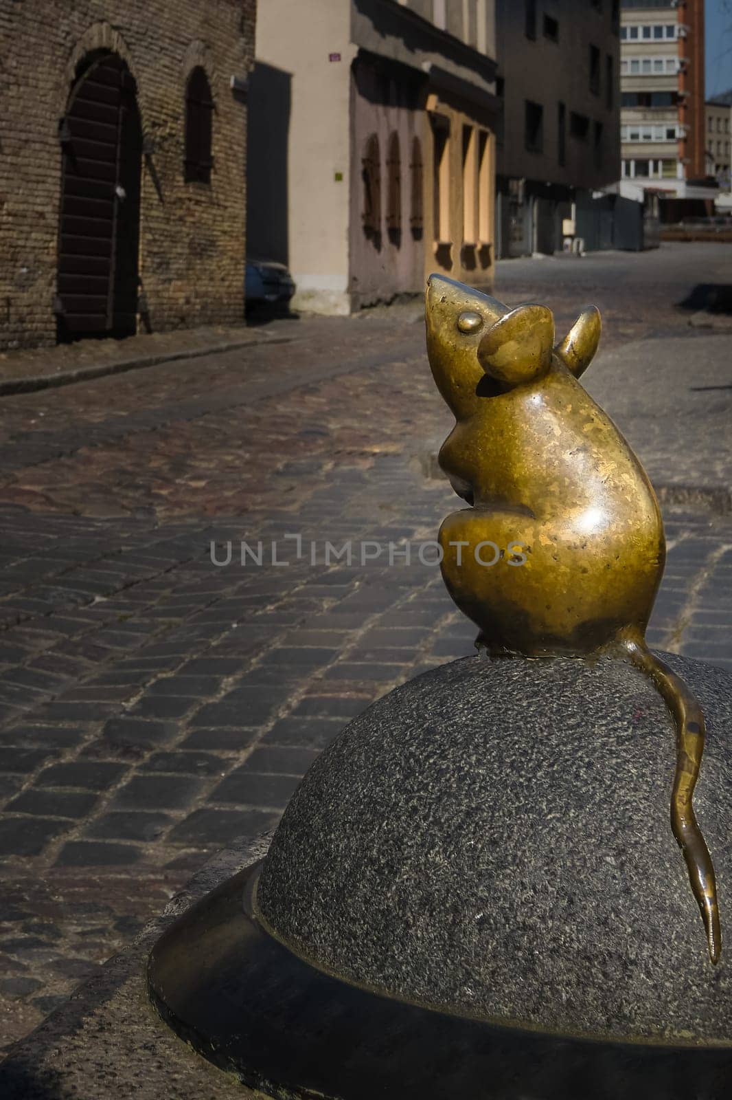 City attraction of tiny mouse street statue in old part of Klaipeda, Lithuania. City symbols, medieval towns, sunny day, cobbled pavement.