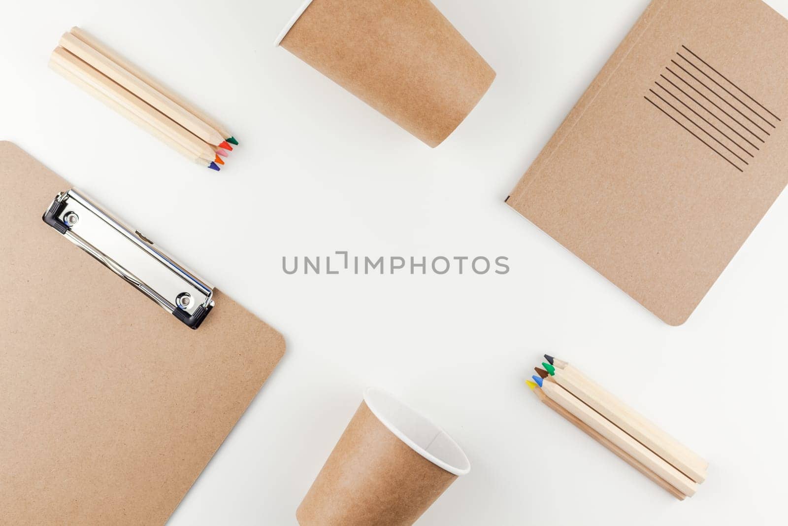 Creative top view flat lay of workspace desk styled recycled brown design office supplies and coffee cups with copy space white table background minimal eco style. Concept of environmental protection