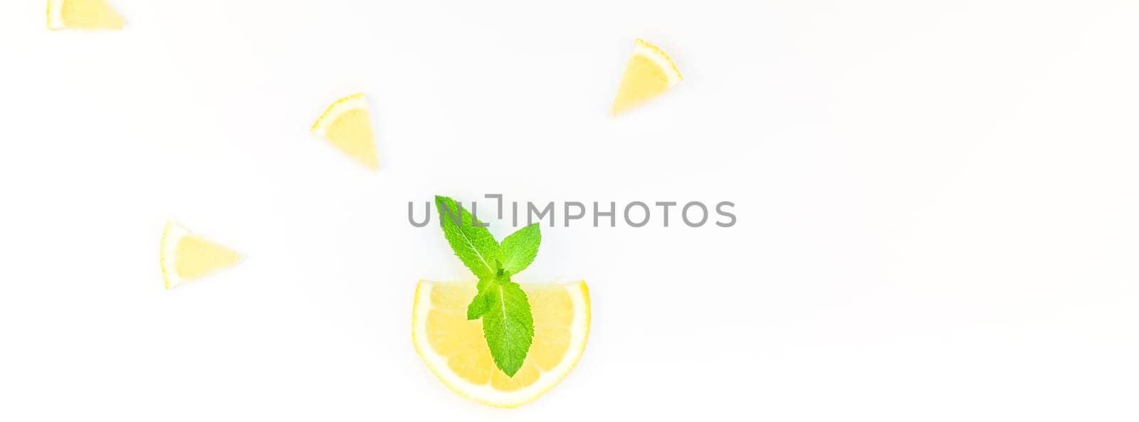 Long wide banner top view citrus lemon slices and mint herbs leaves white table background with copyspace. Hot summer refreshment lemonade concept. Beverage ingredients arranged