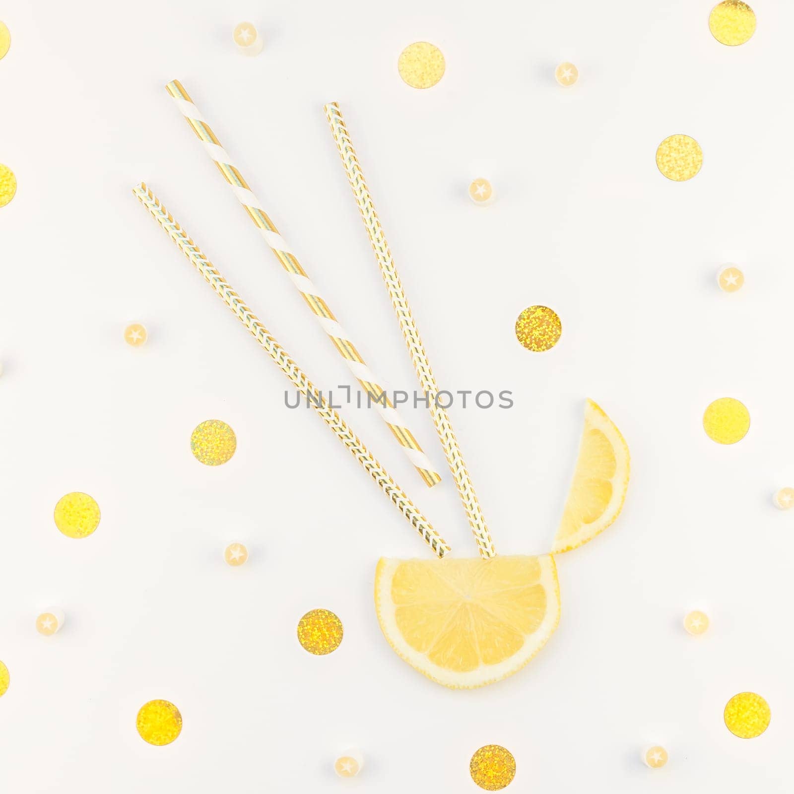 Square flatlay overhead top view citrus lemon slices and candies white table background with copyspace. Hot summer refreshment lemonade concept. Beverage ingredients arranged with straws