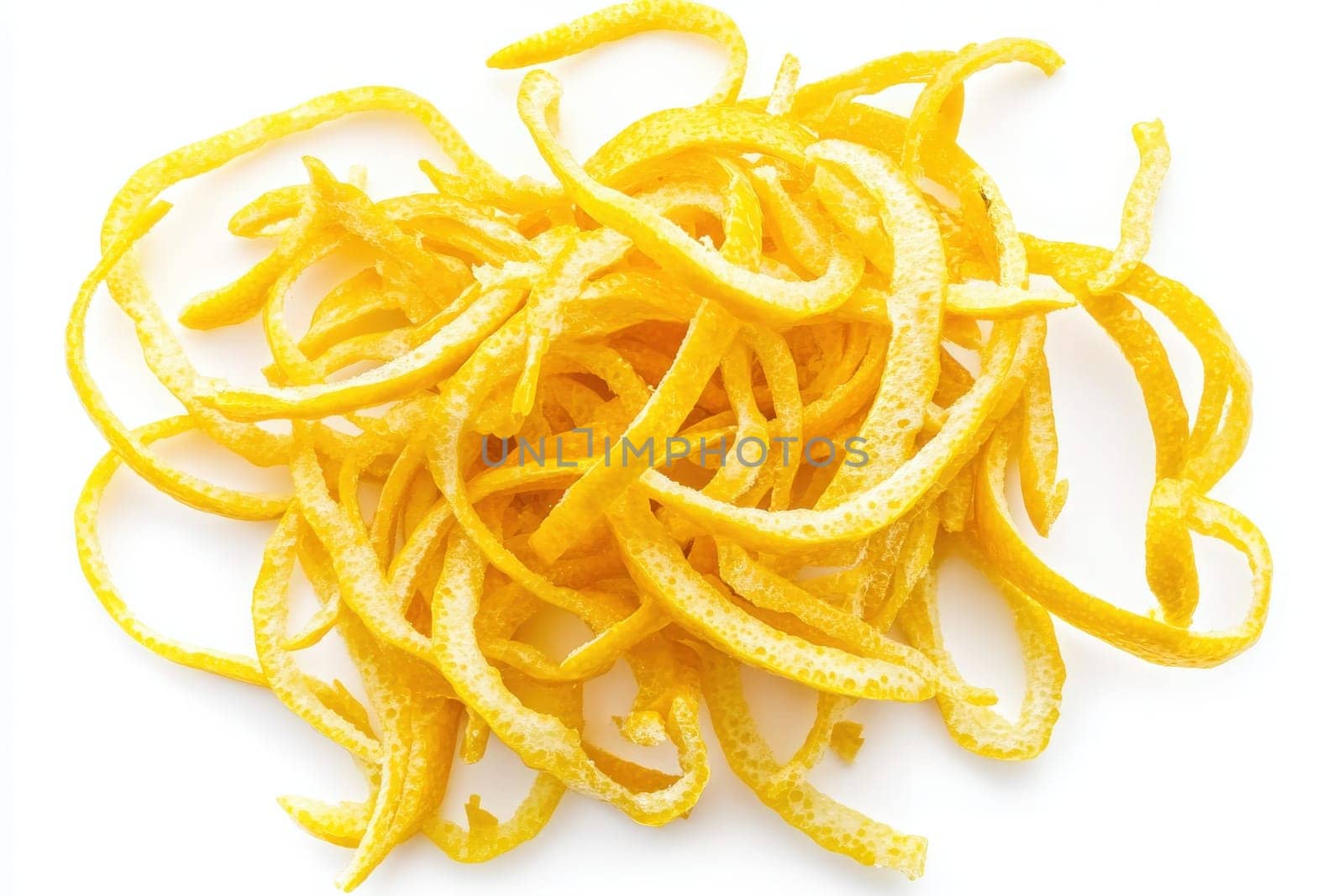 Curled lemon zest is vibrant and bright, showcasing its rich yellow color against a plain white background. This zest adds flavor and aroma to various culinary creations.