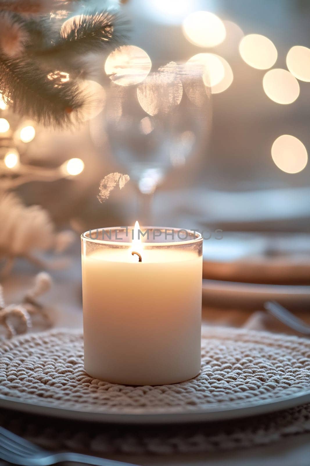 The warm glow of a lit candle enhances the inviting atmosphere of a festive dinner setting with twinkling lights.