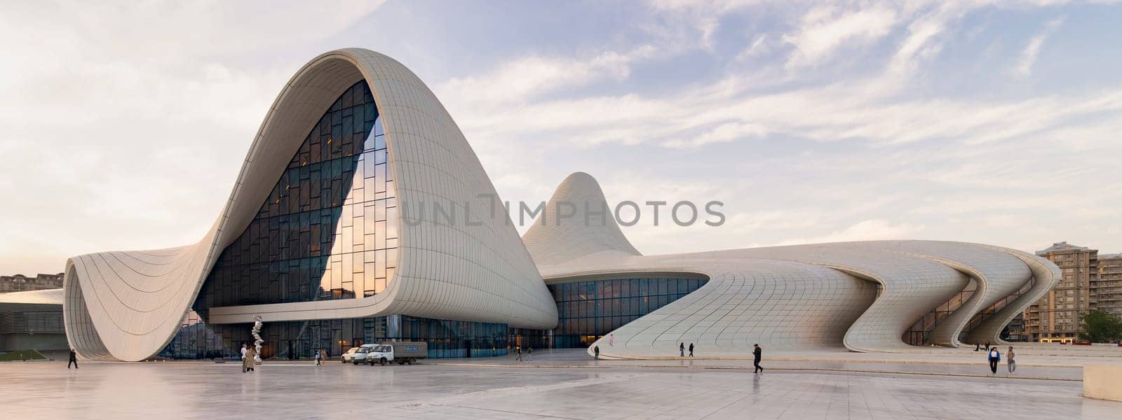 Baku, Azerbaijan - May 11, 2024: The Heydar Aliyev Centre showcases its unique fluid design and striking angular lines, bathed in warm sunset light