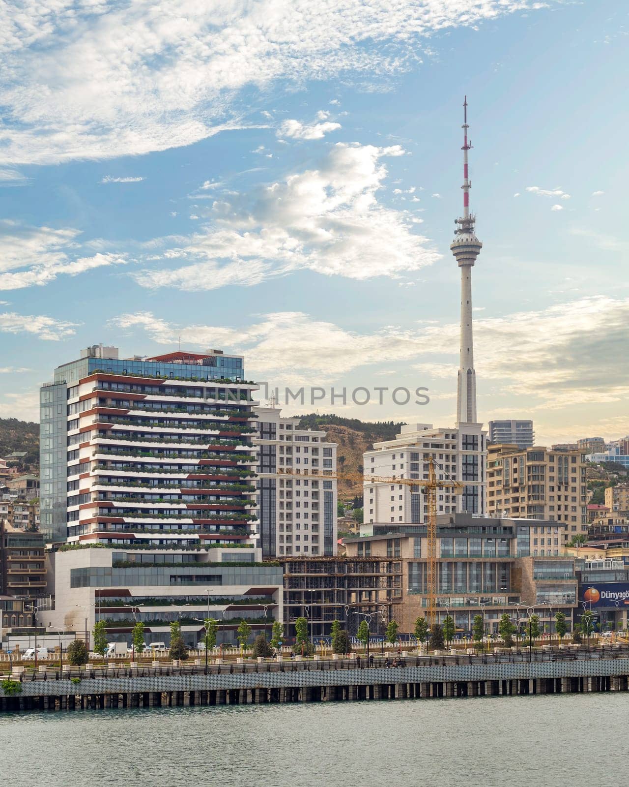 The Baku TV Tower rises alongside contemporary tall buildings against the backdrop of the Caspian Sea over the city of Baku, Azerbaijan