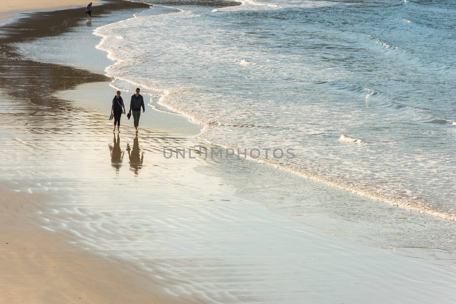 FRANCE, HENDAYE - SEPTEMBER 23: happy romantic couple walking on the atlantic beach. travel vacation on September 23, 2015