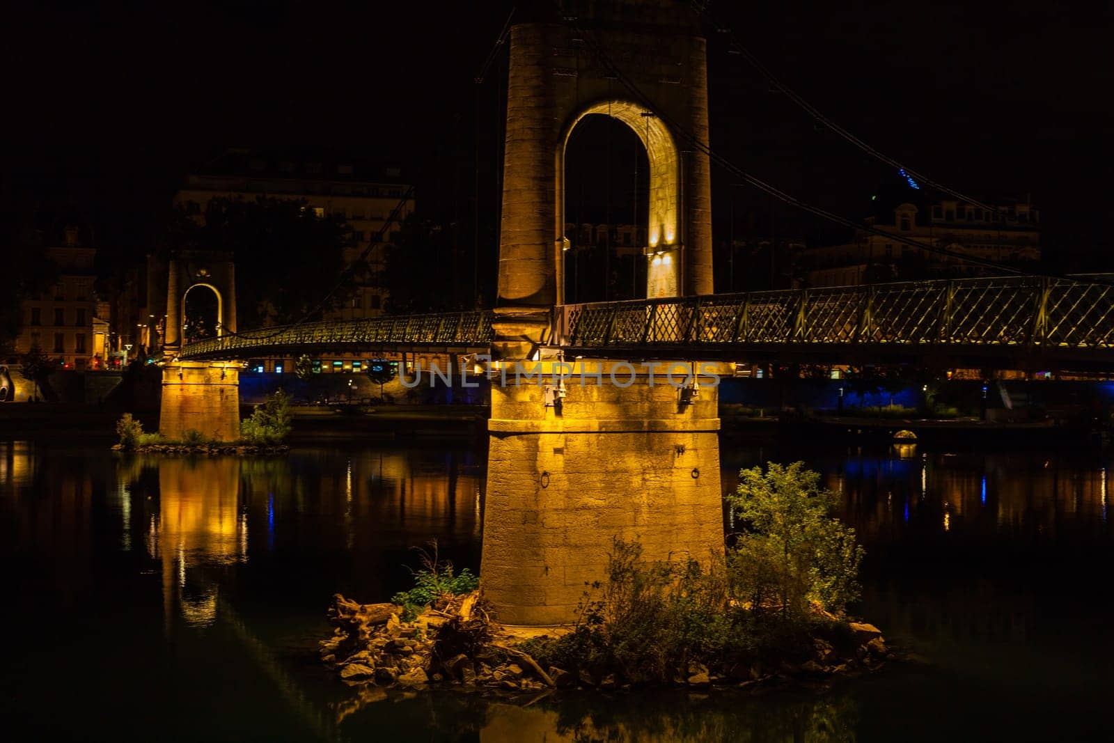 Old Passerelle du College bridge over Rhone river in Lyon, France at night