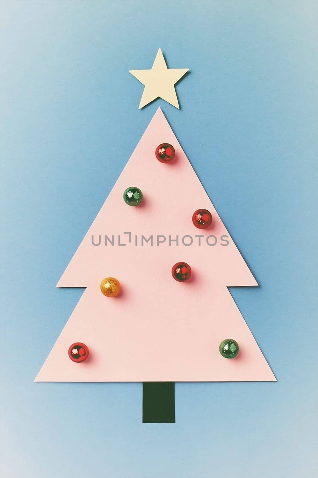 A pastel-colored Christmas tree displayed with vibrant ornaments and a star, set against a soft blue backdrop for festive cheer.