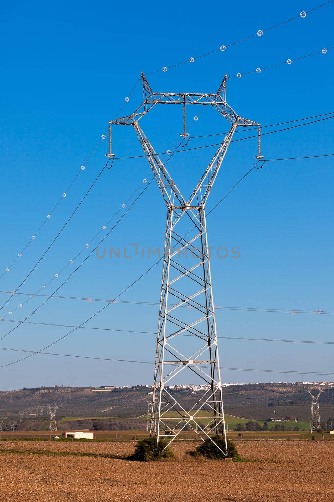Electricity Power Pylons against Bright Blue Sky at a Beautiful Countryside