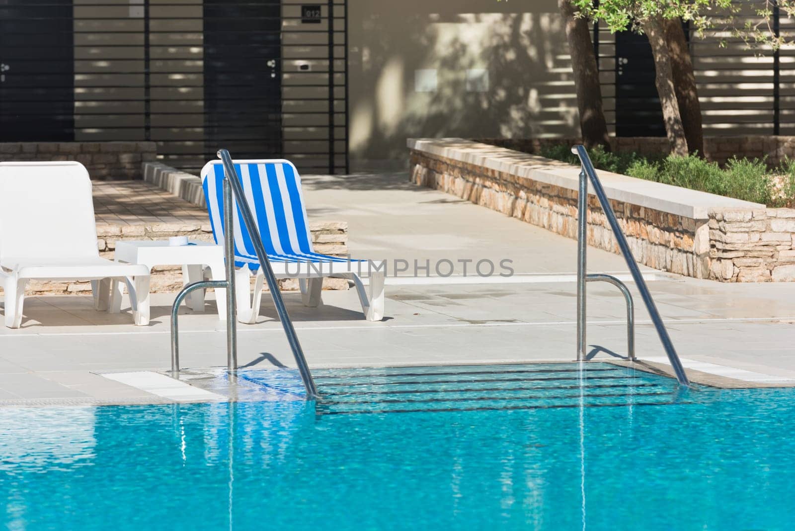 Hotel Poolside Chairs near a swimming pool. Summer shot