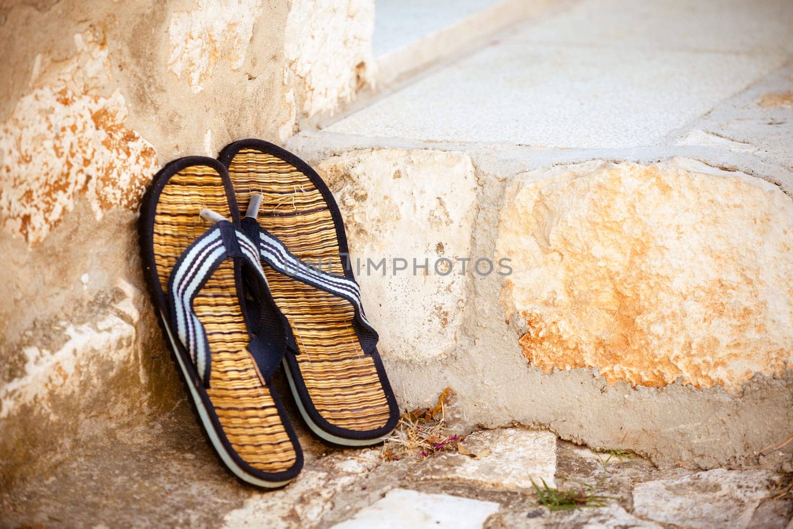 Beach flip-flops on the old wall background. Horizontal shot