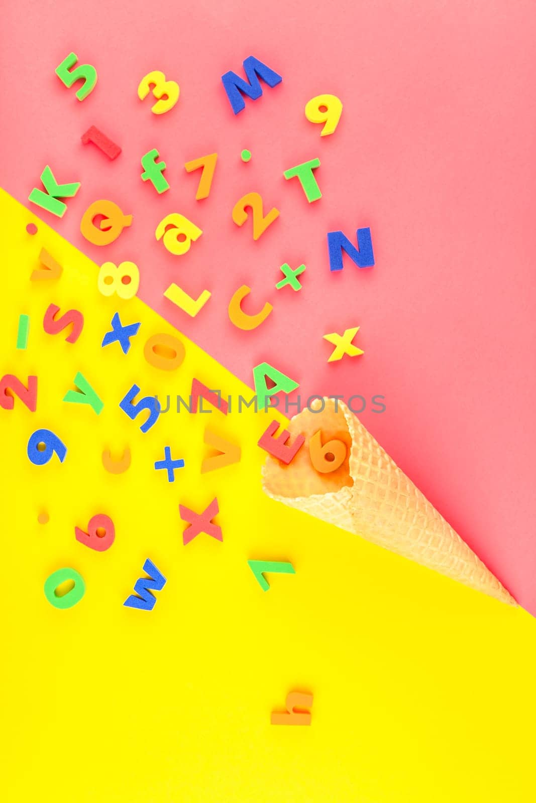Creative flat lay back to school concept with waffle cone and welcome letters message on bright yellow and pink paper background with copy space, template for text or design