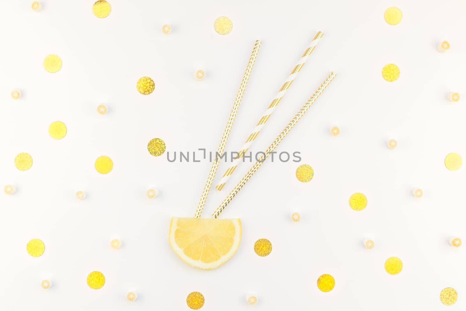 Creative flatlay overhead top view citrus lemon slices and candies white table background with copyspace. Hot summer refreshment lemonade concept. Beverage ingredients arranged with straws