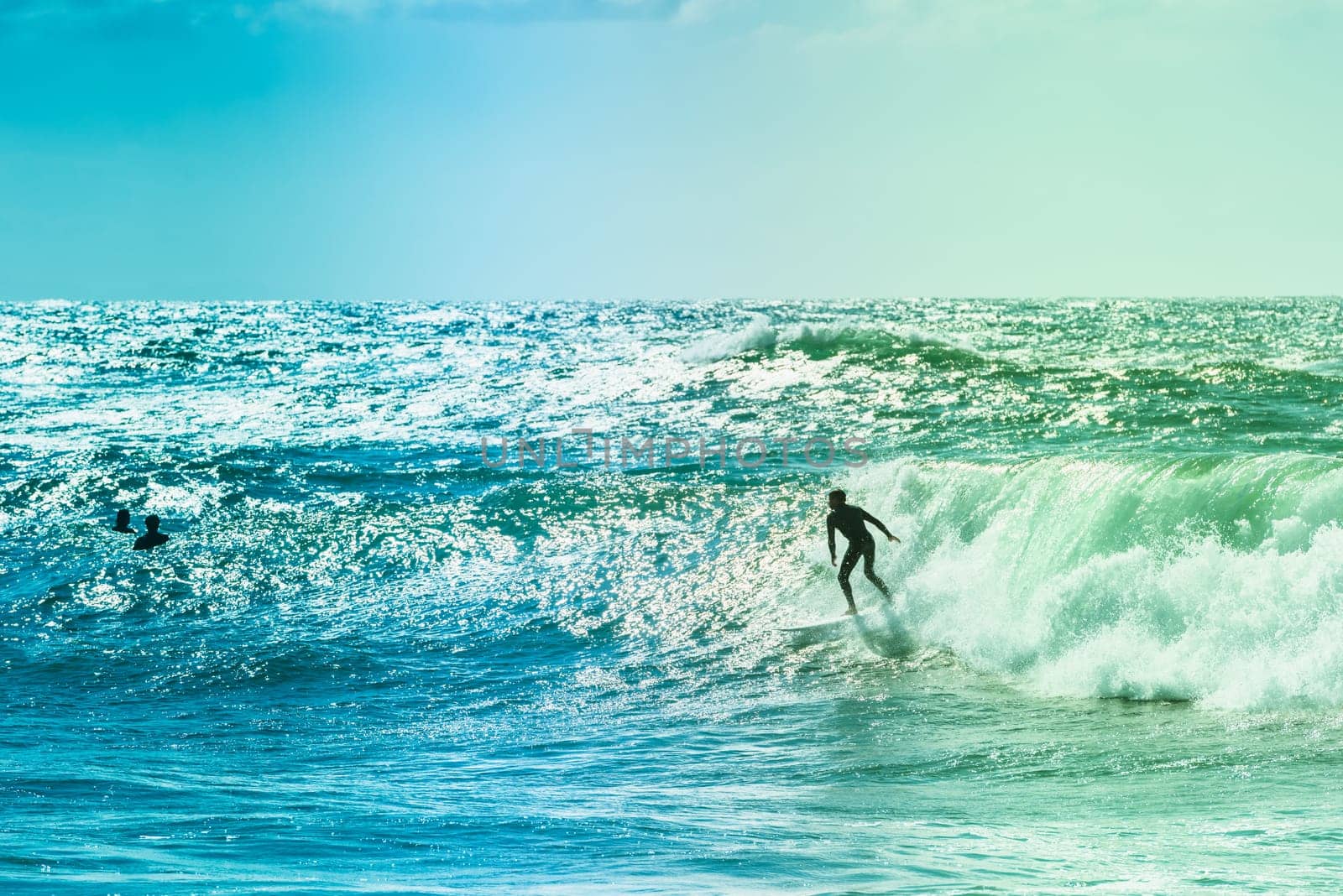 Extreme surfers riding some waves on the sea in France
