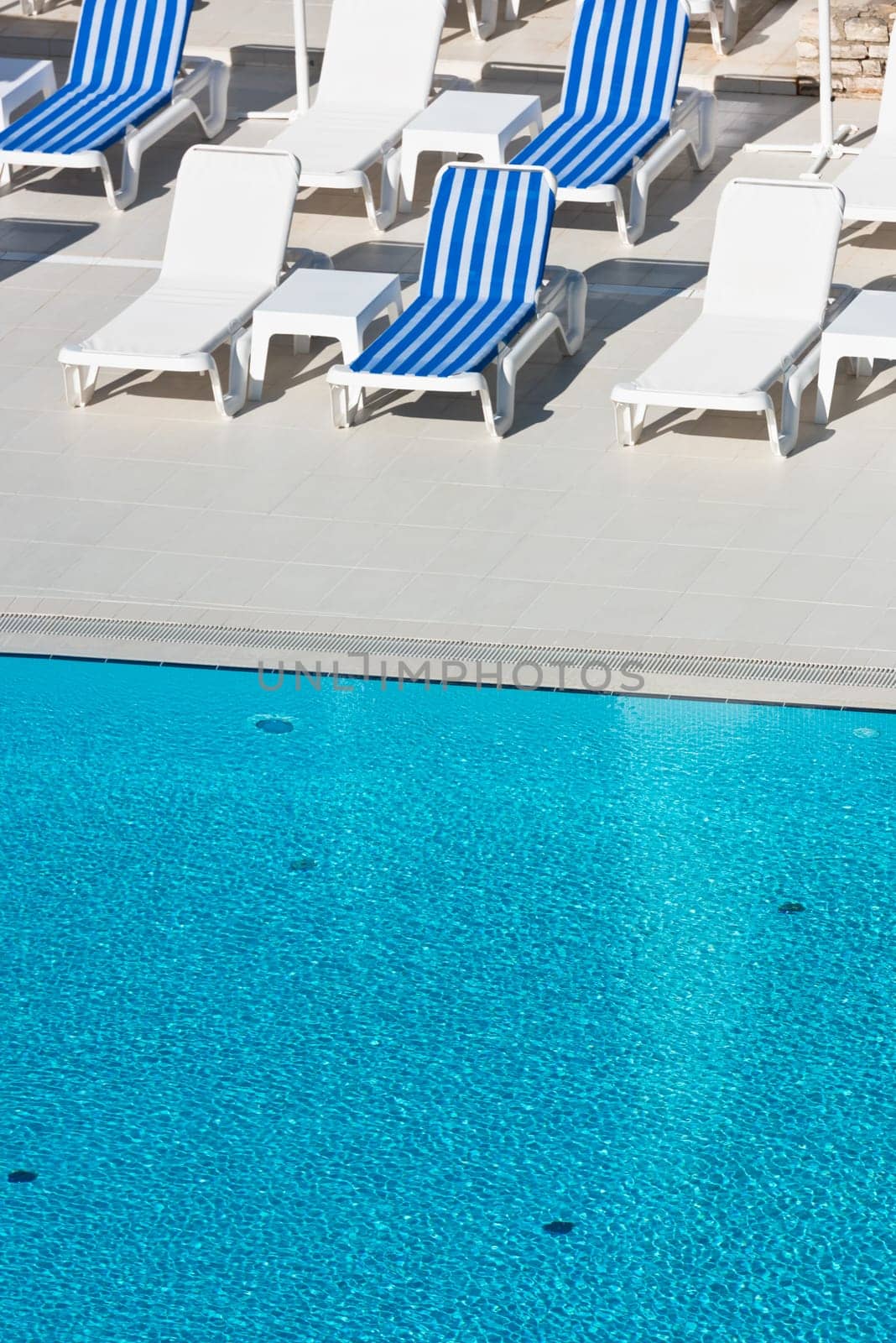 Hotel Poolside Chairs near a swimming pool. Summer shot