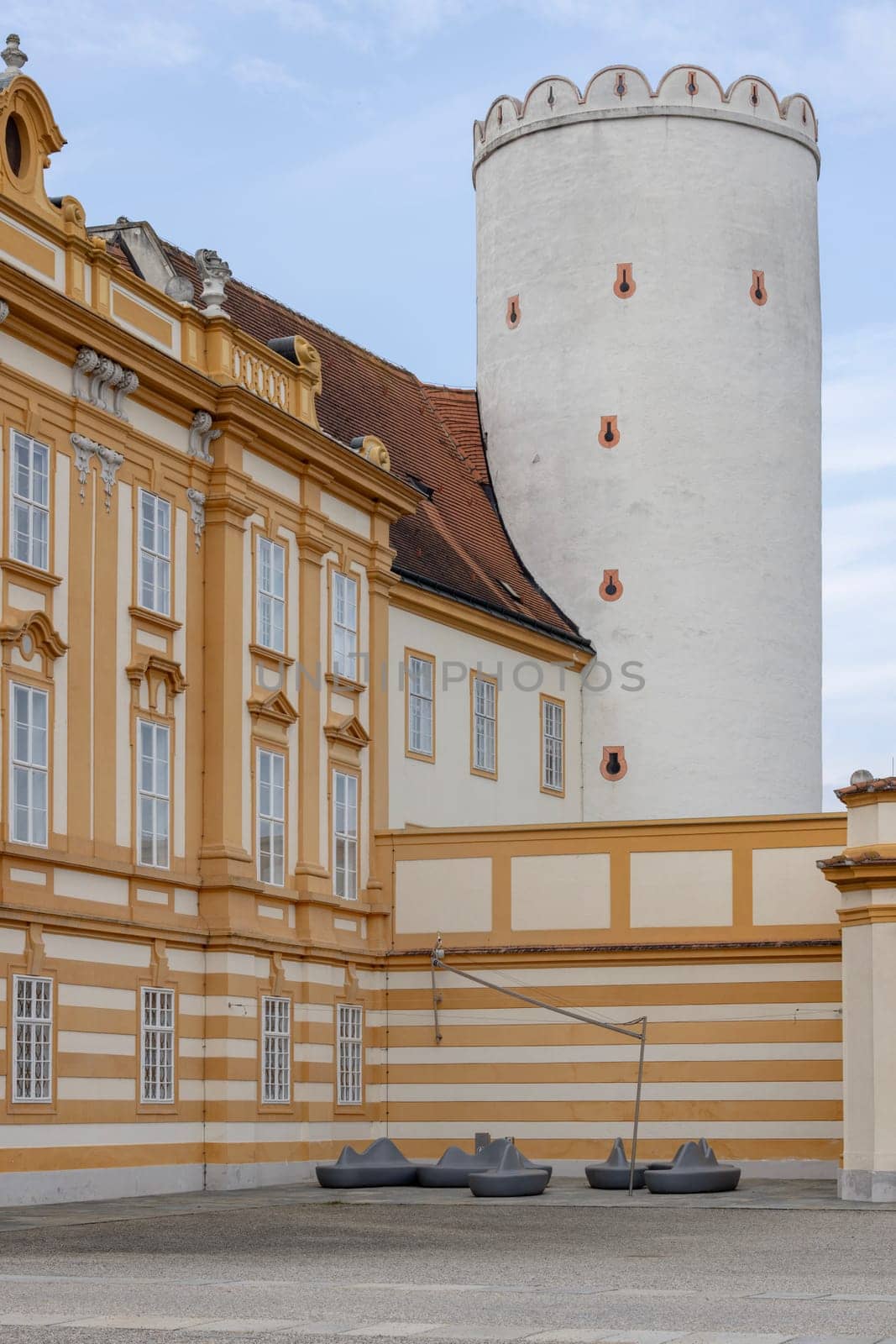 Melk, Austria - February 24, 2023: Courtyard at the entrance to Melk Abbey with a round defensive tower. Monastery was founded in 11th century, today's baroque abbey was built in 18th century