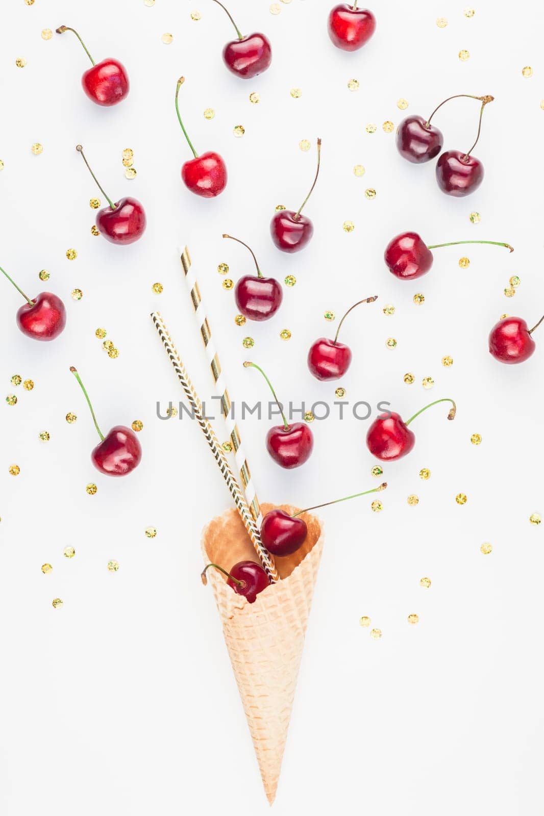Creative top view of ripe cherries in a waffle cone with copy space isolated on white background in minimal style. Concept of summer fun and healthy eating. Template for your text or design.
