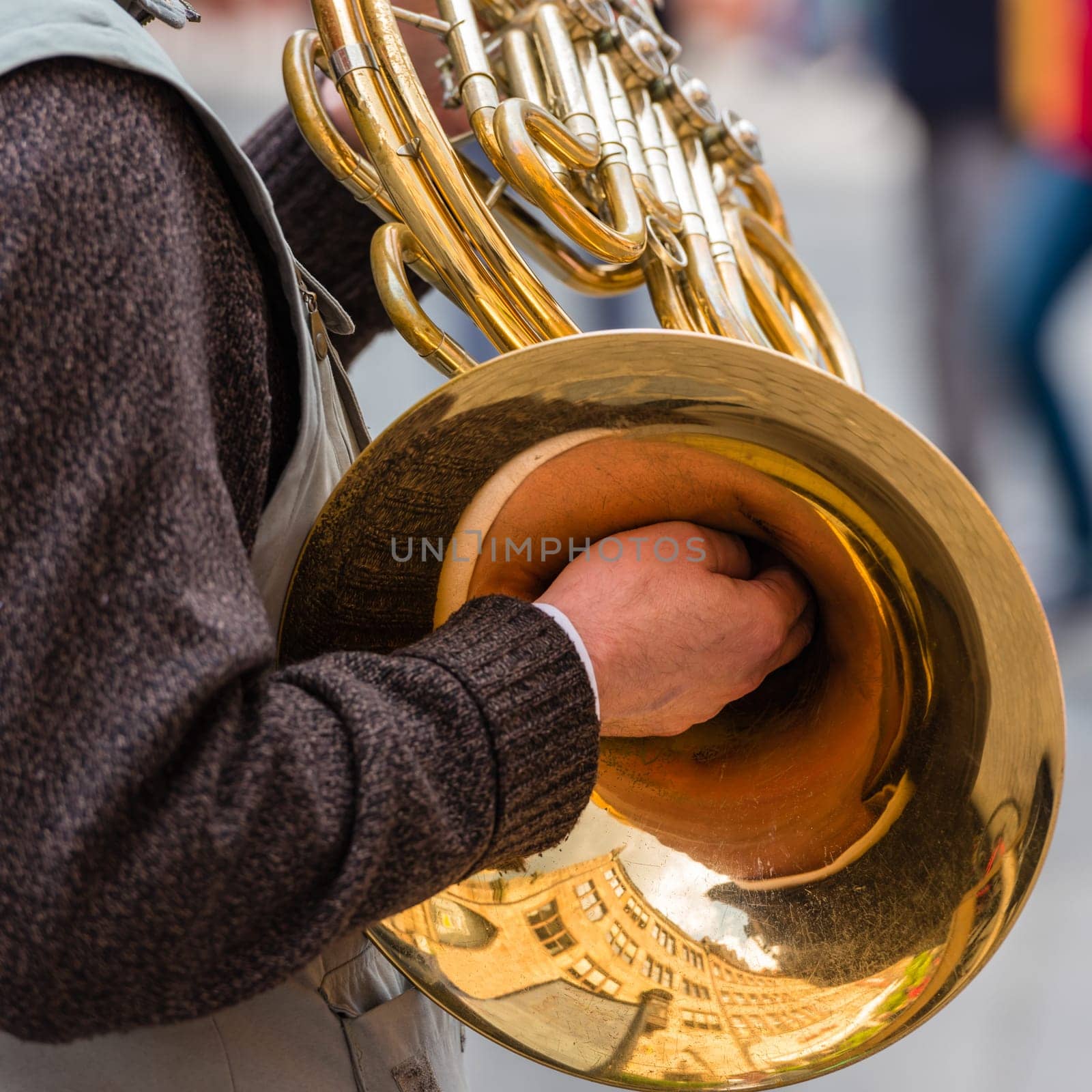 male street musician playing on the trumpet. square shot
