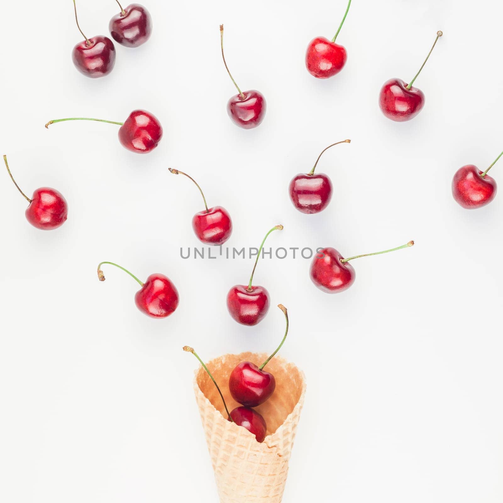Square Creative top view of ripe cherries in a waffle cone with copy space isolated on white background in minimal style. Concept of summer fun and healthy eating. Template for your text or design.
