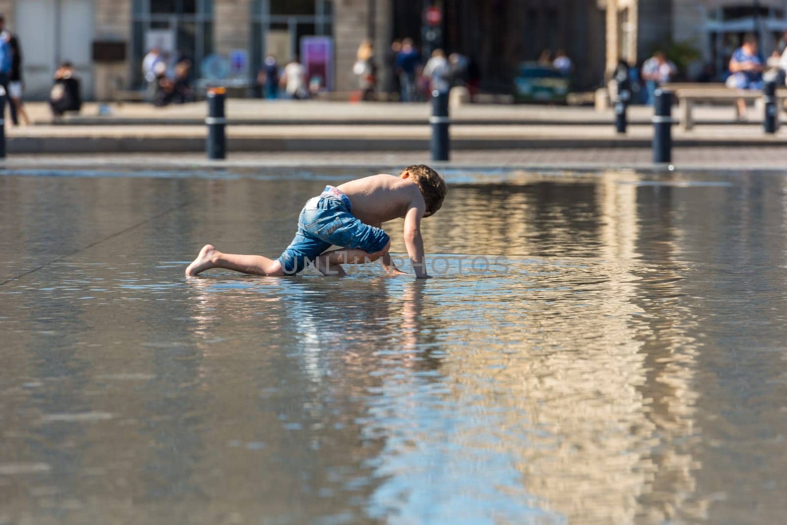 FRANCE, BORDEAUX - SEPTEMBER 20: People having fun in a mirror fountain in front of Place de la Bourse in Bordeaux, France on September 20, 2015