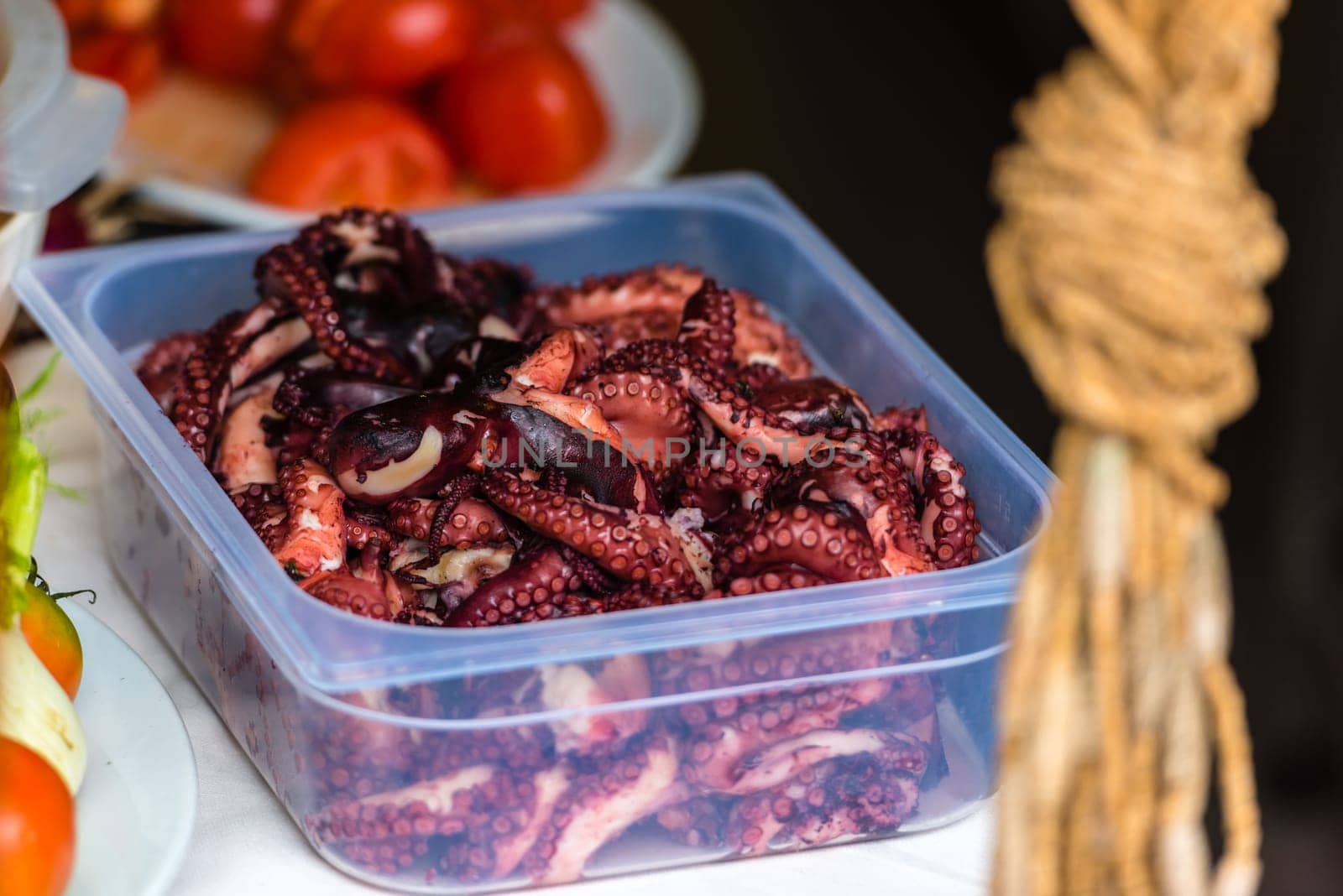 Cooked octopus parts in a box ready for serving in a restaurant