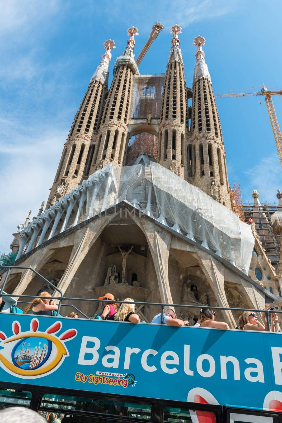 SPAIN, BARCELONA - SEPTEMBER 13: People sitting on a double decker tourist coach in front of The Sagrada Familia Cathedral in Barcelona on September 13, 2015
